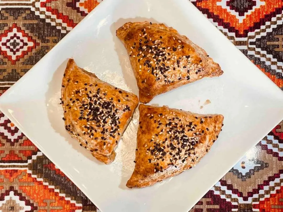 Triangular pastries sprinkled with sesame and other seeds at Babahan Uyghur Cafe, a Chinese Xinjiang Flavors Restaurant in Plano