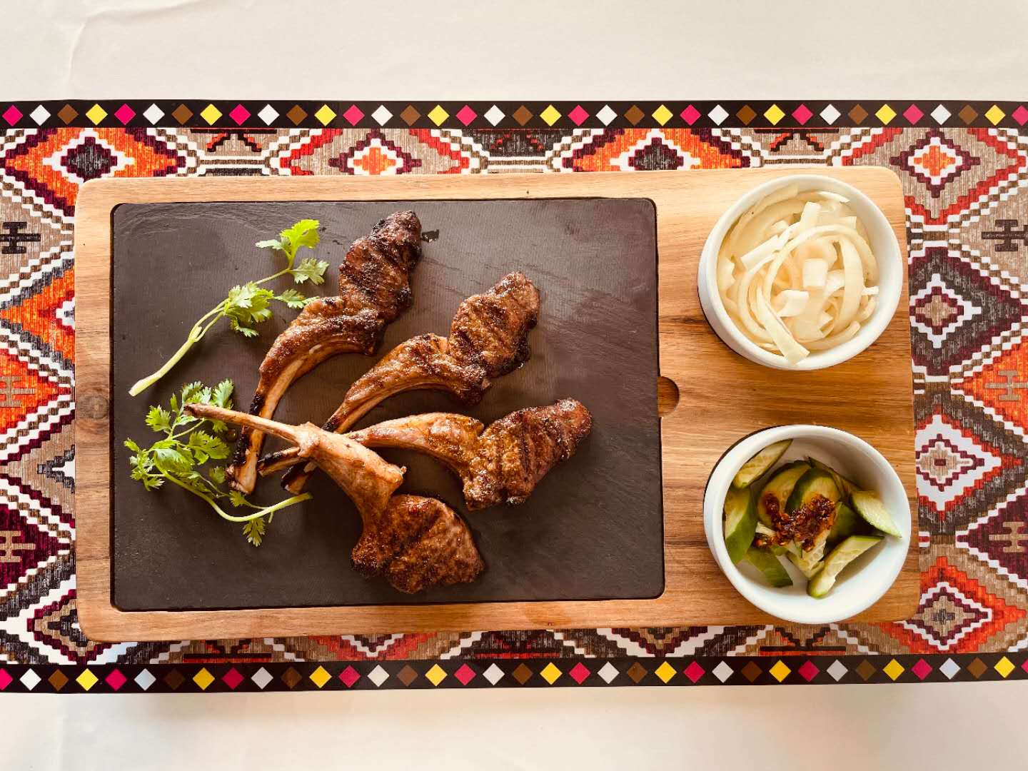 Grilled lamb chops served with pickled vegetables at Babahan Uyghur Cafe, a Chinese Xinjiang Flavors Restaurant in Plano