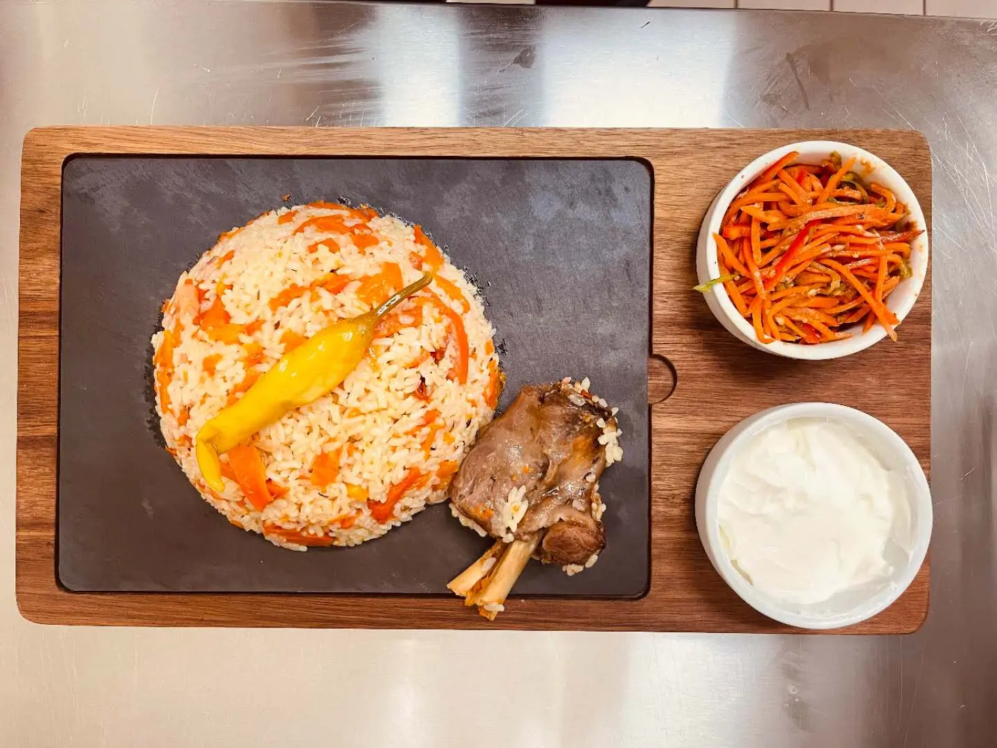 Xinjiang pilaf with lamb, served with side dishes at Babahan Uyghur Cafe, a Chinese Xinjiang Flavors Restaurant in Plano